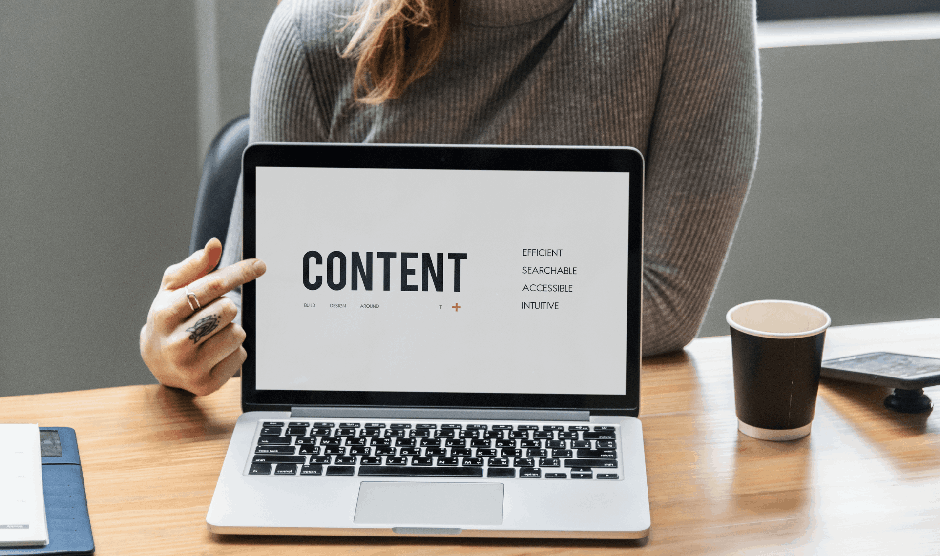 Laptop showing content strategy keywords held by a marketing professional.