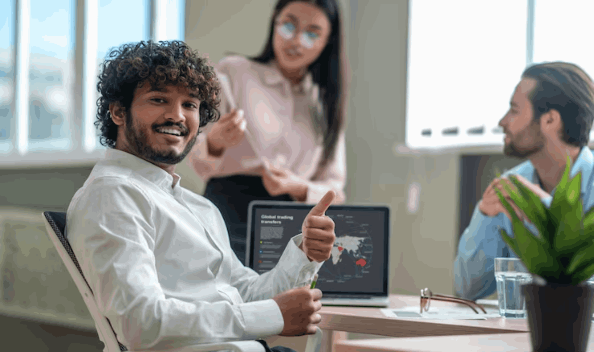 Team in office meeting with laptop dashboard, relaxed collaboration with no infrastructure headaches.