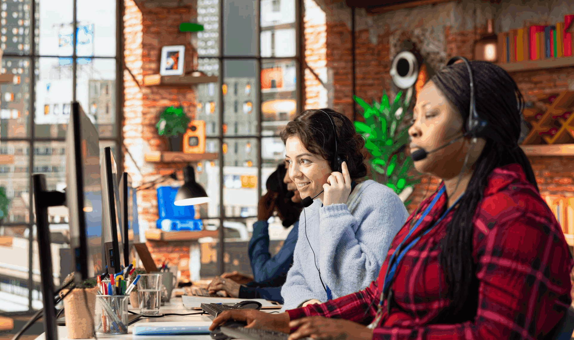Support team members wearing headsets and working at computer stations in a modern office environment - Dedicated Support Teams.